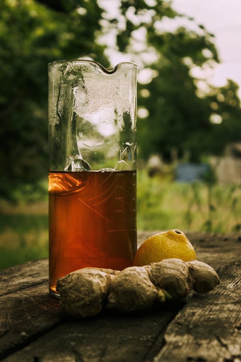 Chilled lemon ginger tea with fresh ingredients on rustic table, perfect for a summer refreshment.